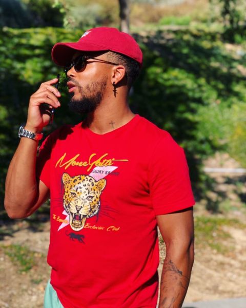 Romeo Miller in a red t-shirt poses a picture.